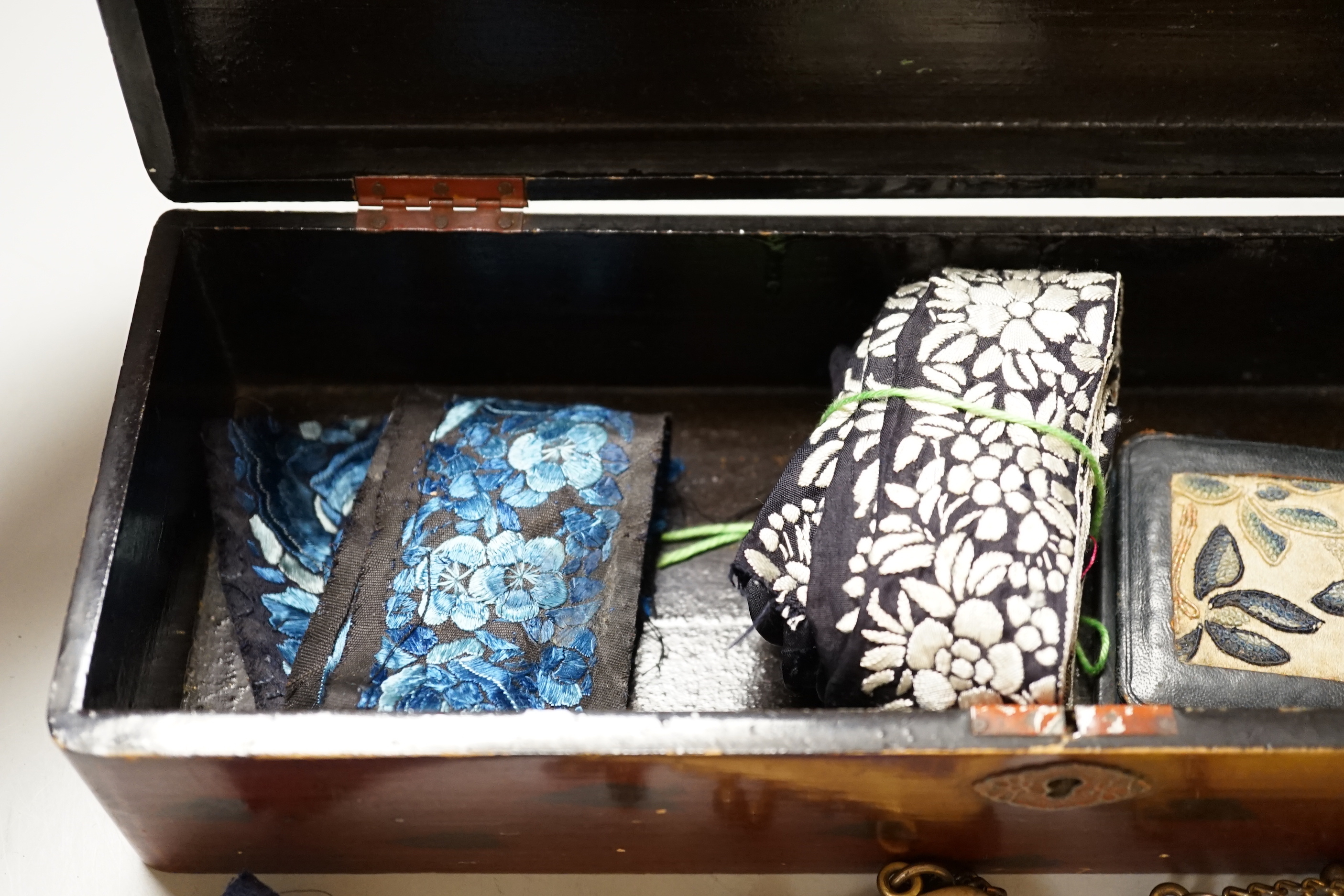 A lacquer box of Chinese embroidered purses and embroideries.
